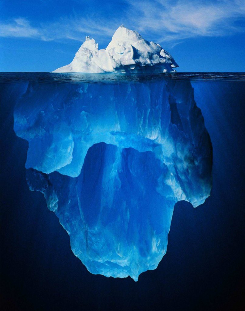 An iceberg showing the small visible tip above water and the massive volume hidden beneath